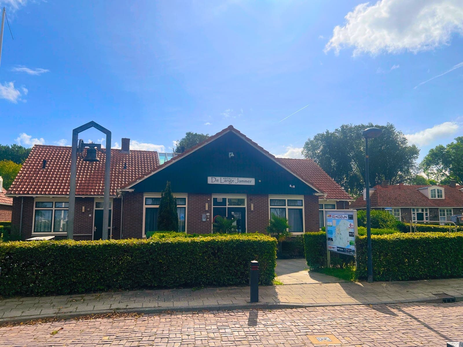 Hotel de Lange Jammer vanaf de straat, met de klokkenstoel naast de ingang