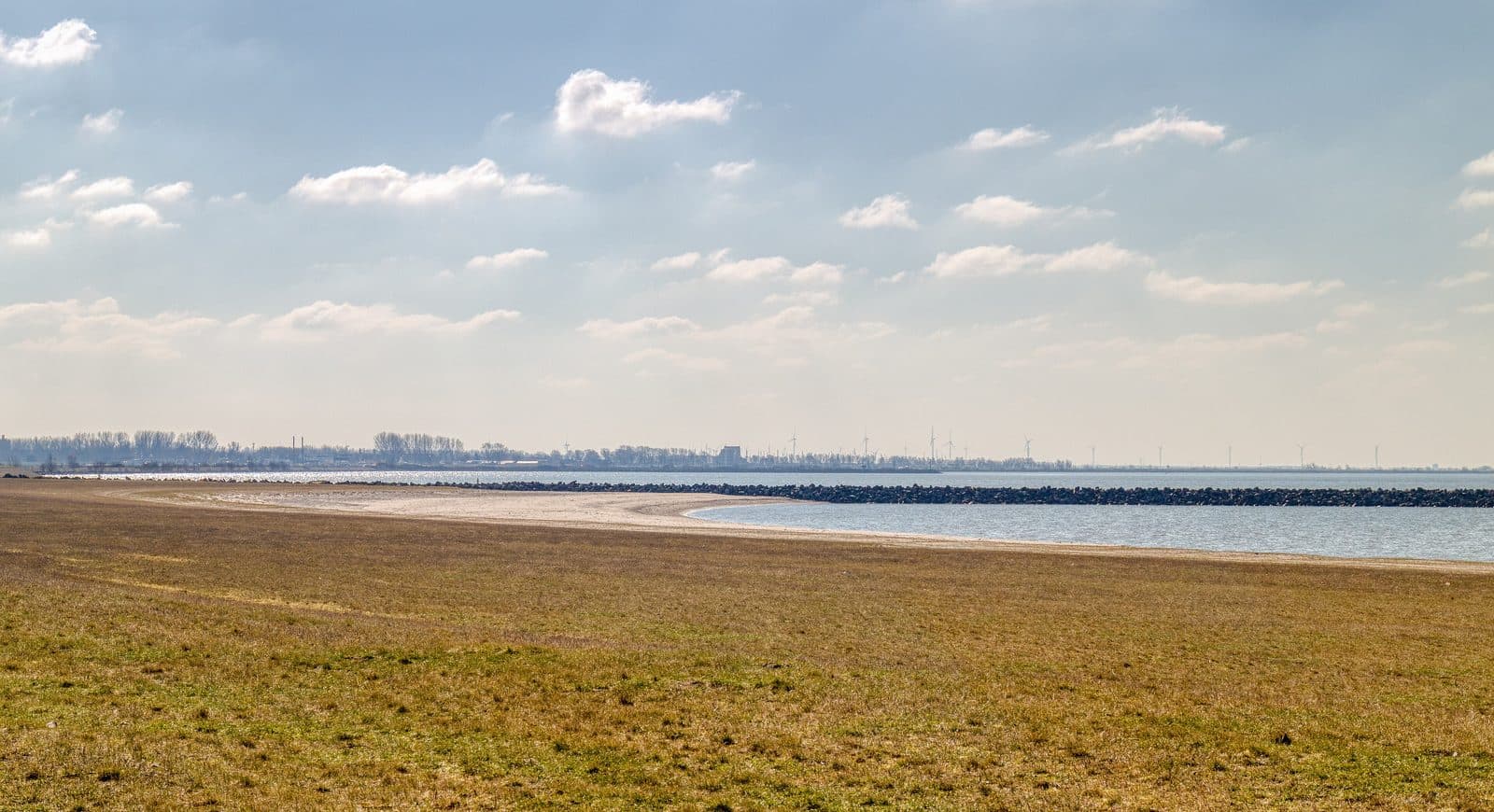 Het brede Bataviastrand met gras en zand, en het Markermeer erachter