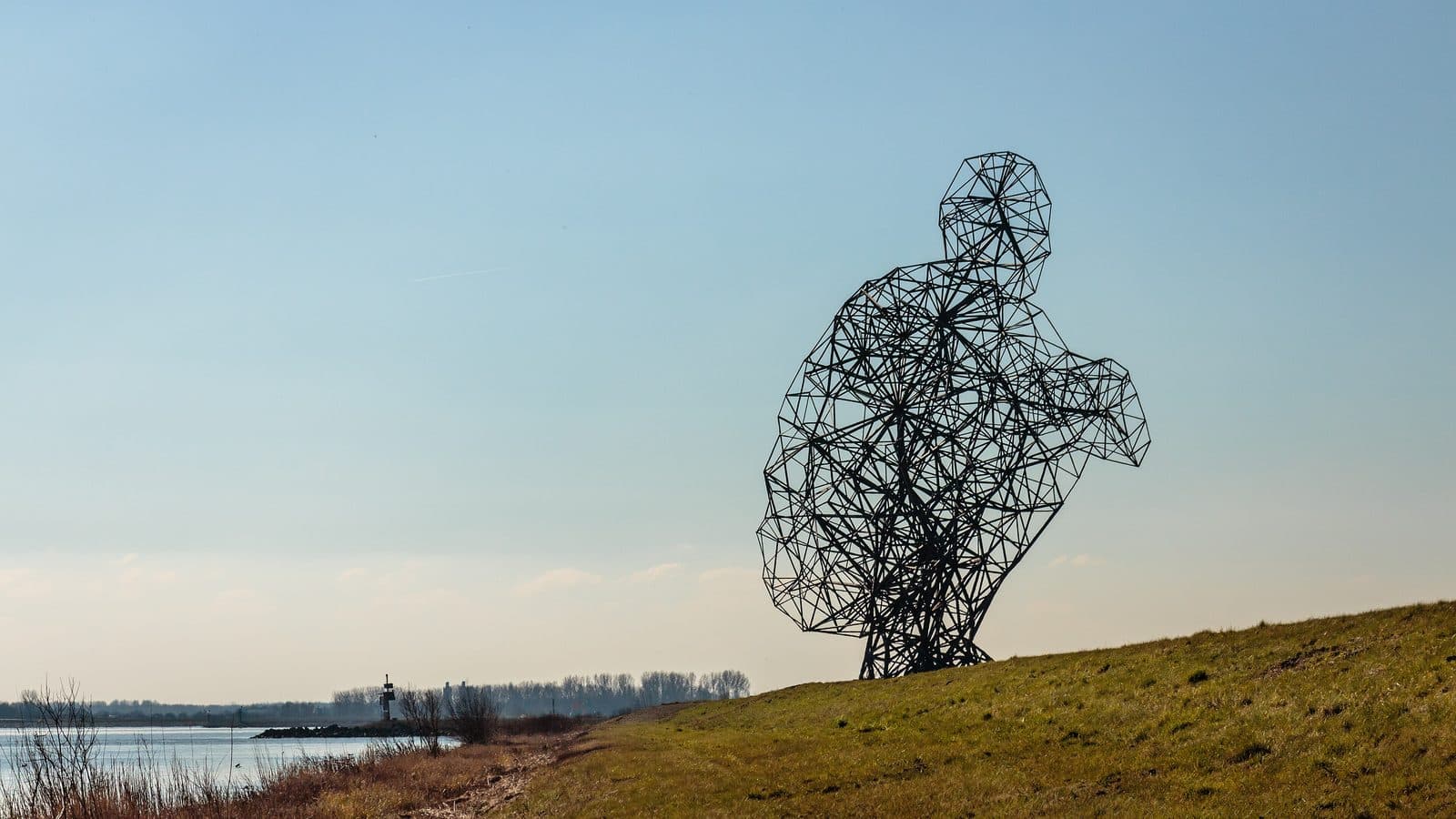 Het stalen beeld Exposure op de dijk, met het water erachter